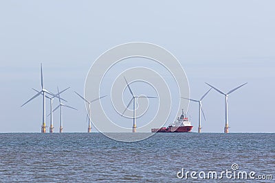 Offshore wind farm turbines with maintenance supply vessel ship Stock Photo