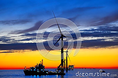 Offshore windfarm construction at sunset Stock Photo