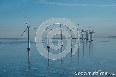 Offshore windmill park alternative energy. windmills in the sea with reflection in the morning, denmark Stock Photo