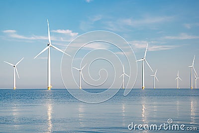 Offshore windmill park with stormy clouds and a blue sky, windmill park in the ocean Stock Photo