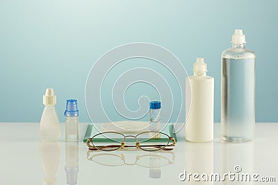 Oftalmology concept with eyeglasses, contact lenses, eye drops, clean solutions Stock Photo