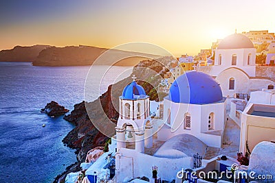 Oia town on Santorini island, Greece at sunset. Rocks on Aegean sea. Stock Photo