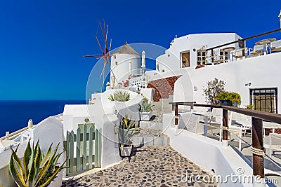 Oia town, Santorini island, Greece. Windmills on cliff, cobled s Editorial Stock Photo