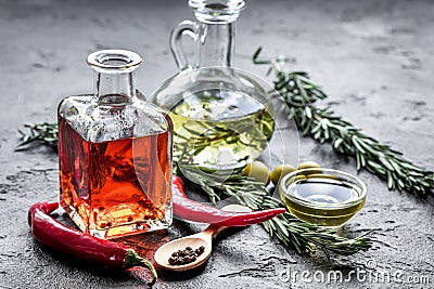 Oil in carafe with spices, olives and chili on stone background Stock Photo