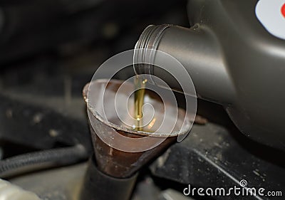 Oil change in the engine of the car. Filling the oil through the funnel. Car maintenance station. Stock Photo