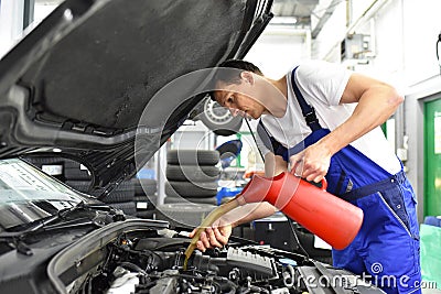 oil change from the engine of a car in a workshop by a professional mechanic - after-sales service Stock Photo