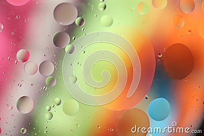 Oil drops in water on a colored background. A bright background with pink, orange, green and blue circles of different sizes. OBlu Stock Photo