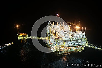 Oil and gas construction in night view. View from helicopter night flight. Oil and gas platform in offshore. Stock Photo