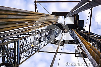 Oil and Gas Drilling Rig onshore dessert with dramatic cloudscape. Oil drilling rig operation on the oil platform in oil and gas Stock Photo