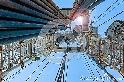 Oil and Gas Drilling Rig onshore dessert with dramatic cloudscape. Oil drilling rig operation on the oil platform in oil and gas Stock Photo