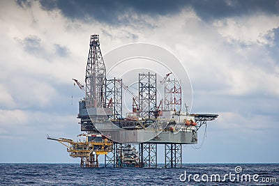 Oil and gas drilling rig working on remote wellhead platform to Stock Photo