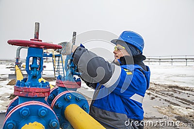 Oil, gas industry. The mechanic - the repairman, gas production operator opens the valve, gas equipment and fitting at the well Stock Photo