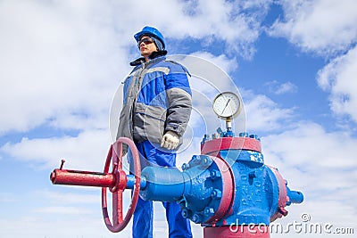 Oil, gas industry. The mechanic - the repairman, gas production operator opens the valve, gas equipment and fitting at the well Stock Photo