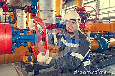 Oil, gas industry. The mechanic - the repairman, gas production operator opens the valve, gas equipment and fitting, toned Stock Photo