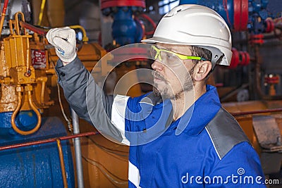 Oil, gas industry. The mechanic - the repairman, gas production operator opens the valve, gas equipment and fitting, toned Stock Photo