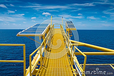 Oil and gas wellhead remote platform, gas cold vent stack and solar cells panel installed at gas vent boom. Stock Photo