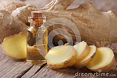 Oil of ginger in a small glass bottle macro and root Stock Photo