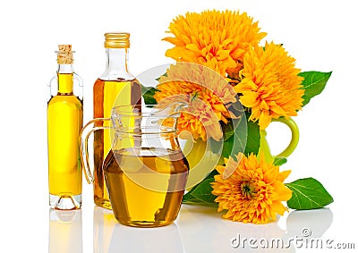 Oil in glass bottle and jug with sunflowers Stock Photo