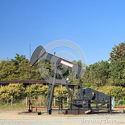 Oil Pump Jack (Sucker Rod Beam) and Reserve Tank Stock Photo