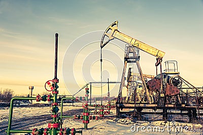 Oil pump jack and wellhead on an oil field. Mining and petroleum industry. Power generation concept. Stock Photo