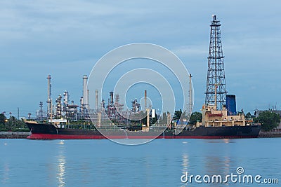 Oil refinery river side with boat tank Stock Photo