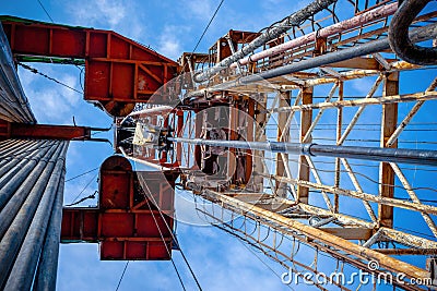 Oil rig derrick in oilfield against the bright blue sky. Drilling rig in oil field for drilled into subsurface in order Stock Photo