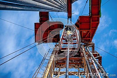 Oil rig derrick in oilfield against the bright blue sky. Drilling rig in oil field for drilled into subsurface in order Stock Photo