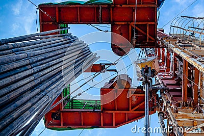 Oil rig derrick in oilfield against the bright blue sky. Drilling rig in oil field for drilled into subsurface in order Stock Photo