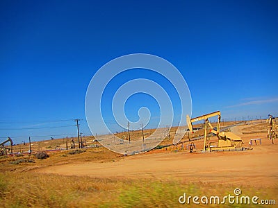 Oil rigs/oil drilling equipment in a field in a california valley Stock Photo