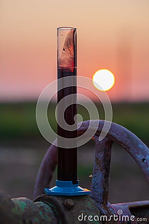 Oil sample in a test tube on an oil pump Stock Photo