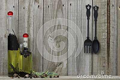 Oil spice jars with cast iron spoon and fork against wood background Stock Photo