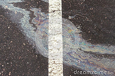 Oil spill on wet asphalt, parking lot with dividing line Stock Photo