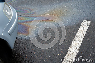 Oil stain or gasoline caused by a leak under a car. Environmental pollution concept. Stock Photo