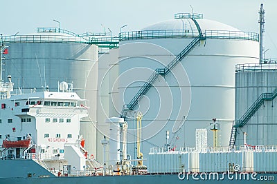 Oil tanker with a background of oil warehouse storage tanks in Rotterdam Stock Photo