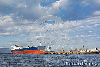 Oil tanker bringing its cargo in a tank storage facility. Stock Photo