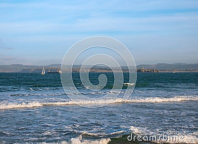 An oil tanker and a sailboat sail along the Cantabrian Sea near the bay of Santander Stock Photo