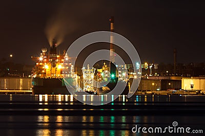 Oil tanker unloading cargo at night Stock Photo