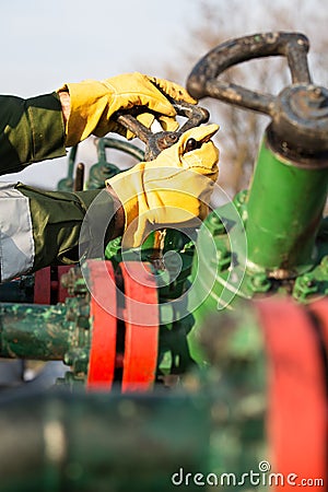 Oil worker turning valve Stock Photo