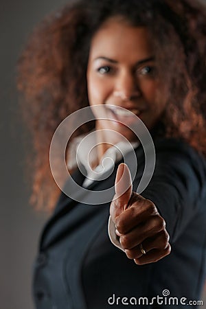 ok! Black woman's enthusiastic thumbs-up background joy blurred Stock Photo