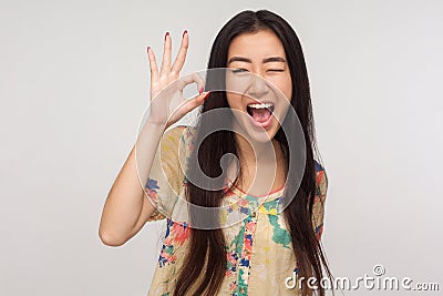 Ok I got it! Playful delighted asian girl with brunette hair in summer blouse winking joyfully and showing okay gesture Stock Photo