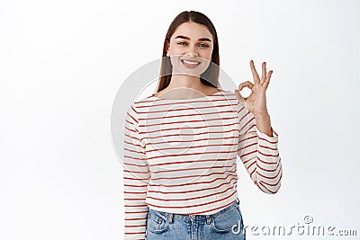 Okay, I agree. Smiling cute girl shows OK sign in approval, praise good think, make compliment, recommend and like Stock Photo