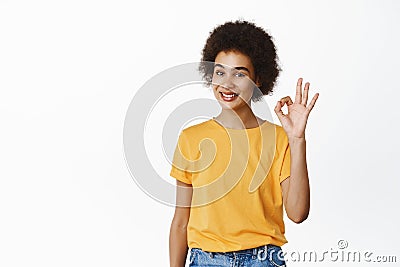 Okay, no problem. Smiling Black young woman, beautiful girl showing ok, zero sign and looking satisfied, recommending Stock Photo