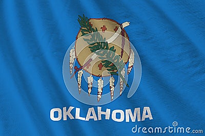 Oklahoma US state flag with big folds waving close up under the studio light indoors. The official symbols and colors in Stock Photo