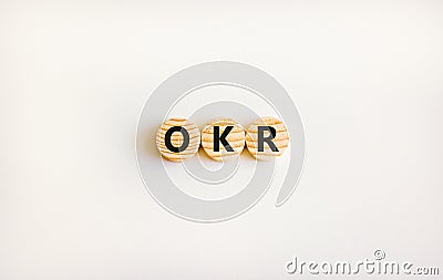 OKR, objectives and key results symbol. Concept words OKR objectives and key results on wooden circles on a beautiful white Stock Photo