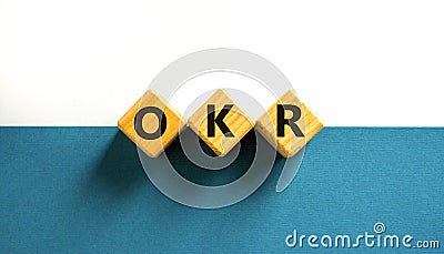 OKR, objectives and key results symbol. Concept words OKR objectives and key results on wooden cubes on a beautiful white Stock Photo