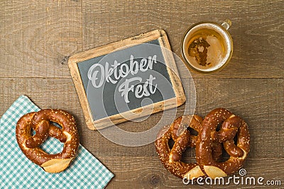 Oktoberfest party concept with pretzel, beer glass and chalkboard over wooden background. Top view, flat lay Stock Photo