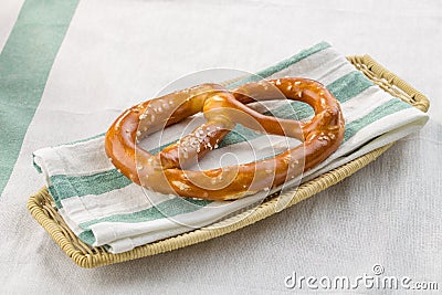 Oktoberfest salted soft pretzel on a plate on textile background Stock Photo