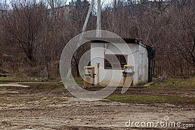 An old abandoned analog fuel station. Industrial zone or production area conquered by nature Stock Photo