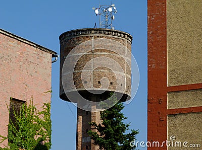 Old abandoned brick water tower detail with radio transmission antenna on top Stock Photo
