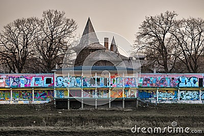 Old abandoned building on the banks of the river, painted with colorful graffiti Cartoon Illustration